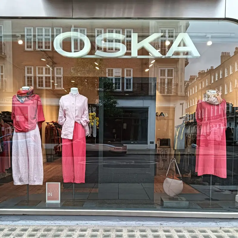 Fashionable clothing displayed in store window.