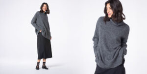 Woman smiling in a cozy gray sweater outfit.