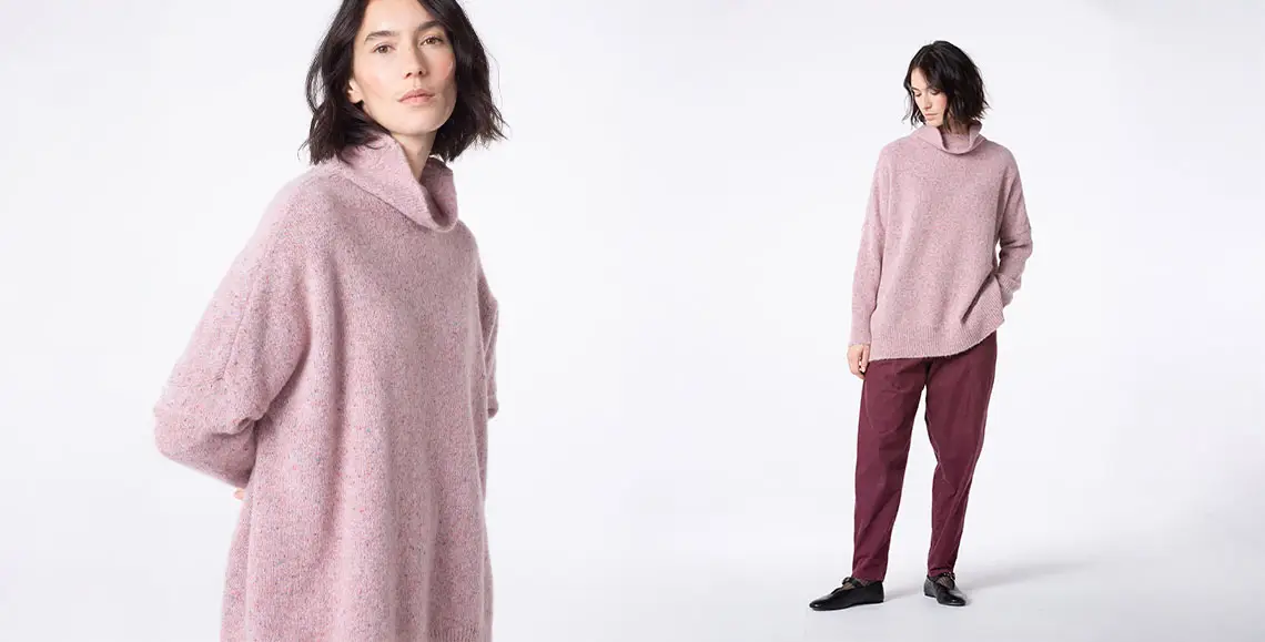 Model showcasing pink sweater and burgundy pants.