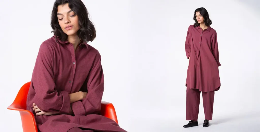 Woman in burgundy outfit seated and standing.